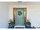 Charming home entrance featuring a green door flanked by planters and a wreath at 1887 Oak Forest E Dr, Clearwater, FL 33759
