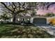Charming single story home with a large tree, landscaped yard and an attached two car garage at 1887 Oak Forest E Dr, Clearwater, FL 33759