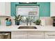 Modern kitchen sink area featuring white countertops and a serene backyard view at 1887 Oak Forest E Dr, Clearwater, FL 33759