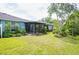 Spacious backyard with green grass, a screened-in patio, and mature trees at 19200 Weymouth Dr, Land O Lakes, FL 34638