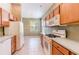 Open-concept kitchen with tile floors, wooden cabinets, and white appliances at 19200 Weymouth Dr, Land O Lakes, FL 34638