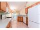 Open kitchen with tile flooring, light countertops, and white appliances overlooking living area at 19200 Weymouth Dr, Land O Lakes, FL 34638