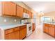 Well-lit kitchen featuring wood cabinets, appliances, and tile flooring at 19200 Weymouth Dr, Land O Lakes, FL 34638