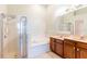 Bright main bathroom featuring double sinks, large soaking tub, and glass enclosed shower at 19200 Weymouth Dr, Land O Lakes, FL 34638