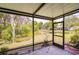 Screened patio featuring tile floors overlooking a lush green backyard and tranquil pond at 19200 Weymouth Dr, Land O Lakes, FL 34638
