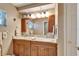A bathroom features a dual sink vanity with granite countertop and warm lighting at 2007 E View Dr, Sun City Center, FL 33573