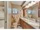 A neutral-toned bathroom features a dual sink vanity with granite countertop and tiled shower at 2007 E View Dr, Sun City Center, FL 33573