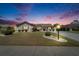 Charming single-Gathering home with manicured lawn and landscaping illuminated by outdoor lighting at twilight at 2007 E View Dr, Sun City Center, FL 33573