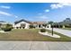 Charming home with a well-manicured front yard, decorative shrubs, and a long driveway at 2007 E View Dr, Sun City Center, FL 33573
