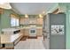 Kitchen with stainless steel refrigerator, light cabinets, and white tile floor at 2007 E View Dr, Sun City Center, FL 33573