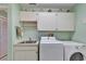 Well lit laundry room with washer, dryer, utility sink and ample storage space at 2007 E View Dr, Sun City Center, FL 33573
