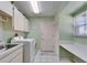 Laundry room with washer, dryer, utility sink and white tiled floor at 2007 E View Dr, Sun City Center, FL 33573