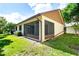 Backyard with a screened-in patio, green grass, and partial shade at 2254 Sequoia Dr, Clearwater, FL 33763