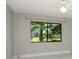 This bedroom features tile flooring, a ceiling fan, and a window for optimal natural light and ventilation at 2254 Sequoia Dr, Clearwater, FL 33763