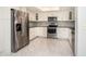 Well-lit kitchen boasts stainless steel appliances, white cabinets, stylish backsplash, and ample counter space at 2254 Sequoia Dr, Clearwater, FL 33763