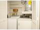 Bright laundry room features a washer, dryer, water heater, and built-in shelving for optimal storage at 2254 Sequoia Dr, Clearwater, FL 33763