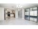 Expansive living space showcases an open-concept design with sleek tile floors, a modern chandelier, and sunroom access at 2254 Sequoia Dr, Clearwater, FL 33763