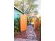Backyard entrance featuring a stone pathway, vibrant foliage, and charming orange gate to the garden area at 2501 Emerson S Ave, St Petersburg, FL 33712