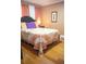 Comfortable bedroom featuring a hardwood floor, a comfortable bed with decorative pillows and a quaint picture on the wall at 2501 Emerson S Ave, St Petersburg, FL 33712