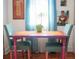 Cozy dining area with a colorful table and chairs, complemented by vibrant artwork and bright curtains at 2501 Emerson S Ave, St Petersburg, FL 33712