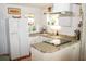 Bright kitchen with white cabinets, tile countertops, stainless steel appliances, and plenty of natural light at 2501 Emerson S Ave, St Petersburg, FL 33712