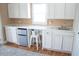 Kitchenette featuring white cabinets, countertop space, a small refrigerator, and a window for natural light at 2501 Emerson S Ave, St Petersburg, FL 33712