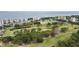 Aerial view showcases condos surrounded by mature trees, a golf course, and scenic water features at 2617 Cove Cay Dr # 108, Clearwater, FL 33760