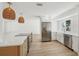 Modern kitchen features stainless steel appliances, an island with seating, and a view of the living area at 2650 E Vina Del Mar Blvd, St Pete Beach, FL 33706