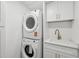 Laundry room with stacked washer and dryer, white cabinets and countertop, and modern fixtures at 2650 E Vina Del Mar Blvd, St Pete Beach, FL 33706