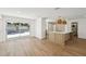 Open-concept living area features wood floors, a central island and sliding doors to the backyard at 2650 E Vina Del Mar Blvd, St Pete Beach, FL 33706