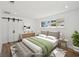 Serene main bedroom with a neutral color palette, sliding barn door closet, and natural light from the large window at 2650 E Vina Del Mar Blvd, St Pete Beach, FL 33706
