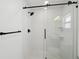 Sleek shower with subway tile surround, glass enclosure, modern black hardware and rainfall shower head at 2650 E Vina Del Mar Blvd, St Pete Beach, FL 33706