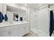 Well-lit bathroom with double vanity, framed mirrors, and a glass-enclosed walk-in shower at 2760 Scarlet Bay Pl, Brandon, FL 33510