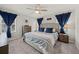 Bright bedroom featuring a ceiling fan, neutral walls, and a beautifully made bed with blue and white linens at 2760 Scarlet Bay Pl, Brandon, FL 33510