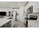 This modern kitchen has stainless appliances, white cabinets, tiled floors and quartz countertops at 2760 Scarlet Bay Pl, Brandon, FL 33510
