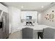 This kitchen features stainless appliances, white cabinets, tiled floors, and seating at the island at 2760 Scarlet Bay Pl, Brandon, FL 33510