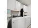 A modern laundry room equipped with a Whirlpool washer and dryer and white cabinets at 2760 Scarlet Bay Pl, Brandon, FL 33510