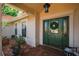 Inviting front door with decorative wreath and sidelights, complemented by a covered brick porch and potted plants at 2796 St Andrews Blvd, Tarpon Springs, FL 34688