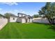 The back yard features a green lawn, a privacy fence, and mature trees at 2930 W Arch St, Tampa, FL 33607
