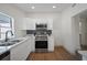 Beautiful kitchen with stainless steel appliances, quartz countertops, wood flooring and sleek white cabinets at 2930 W Arch St, Tampa, FL 33607