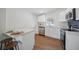 Updated kitchen featuring stainless steel appliances, sleek white cabinets, quartz countertops, and wood floors at 2930 W Arch St, Tampa, FL 33607