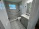 Bathroom showcasing the shower, toilet, vanity and updated flooring at 3239 Jarvis St, Holiday, FL 34690