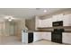 Open-concept kitchen featuring white cabinetry, granite countertops, and a view of the living area at 3629 Bellmeade Ct, Wesley Chapel, FL 33543