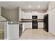Well-lit kitchen featuring white cabinets, black appliances, granite countertops, and tile flooring at 3629 Bellmeade Ct, Wesley Chapel, FL 33543