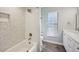 Bright bathroom featuring white subway tile, a tub, and herringbone accent wall at 3994 Belmoor Dr, Palm Harbor, FL 34685