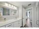 Bright bathroom features a white vanity with ample storage, a large mirror, and a doorway to the commode room at 3994 Belmoor Dr, Palm Harbor, FL 34685