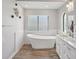 Bathroom featuring a soaking tub, stained-glass window, and wood-look floors at 3994 Belmoor Dr, Palm Harbor, FL 34685