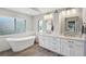 Bathroom featuring a soaking tub, dual sinks, and wood-look floors at 3994 Belmoor Dr, Palm Harbor, FL 34685