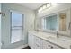 Bright bathroom featuring a double sink vanity with a large framed mirror and wood look floors at 3994 Belmoor Dr, Palm Harbor, FL 34685