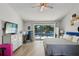 Sunlit main bedroom featuring light wood floors and sliding glass doors to private pool and patio at 3994 Belmoor Dr, Palm Harbor, FL 34685